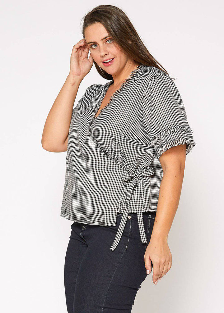 Plus Size Fringe Trim Gingham Wrap Blouse in Black Gingham by Shop at Konus